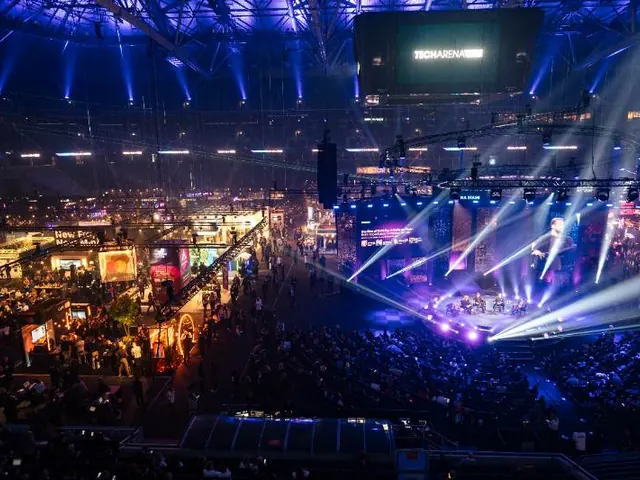 A packed arena during a BuilderBase event, panel on the main stage and exhibition floor below